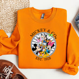 an orange mickey and mickey mouse shirt next to a pair of sneakers