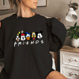 a woman sitting on a bed wearing a black shirt with mickey mouse friends on it