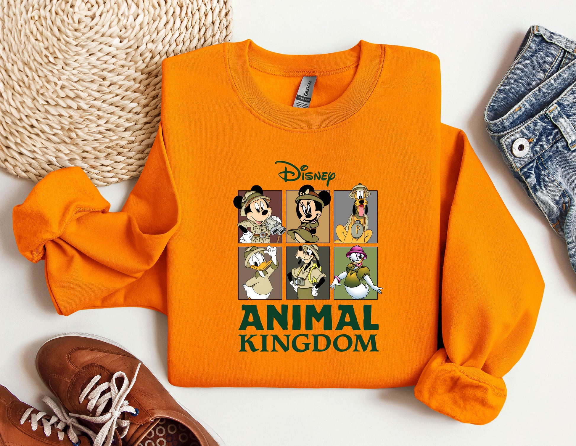 an orange shirt with mickey mouse and other disney characters on it