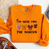a pair of sneakers and an orange sweatshirt with i'm here for the snacks