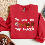 a red sweatshirt with the words i'm here for the snacks printed on it