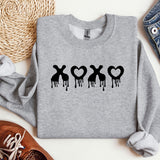 a sweater with the word xo on it next to a pair of shoes