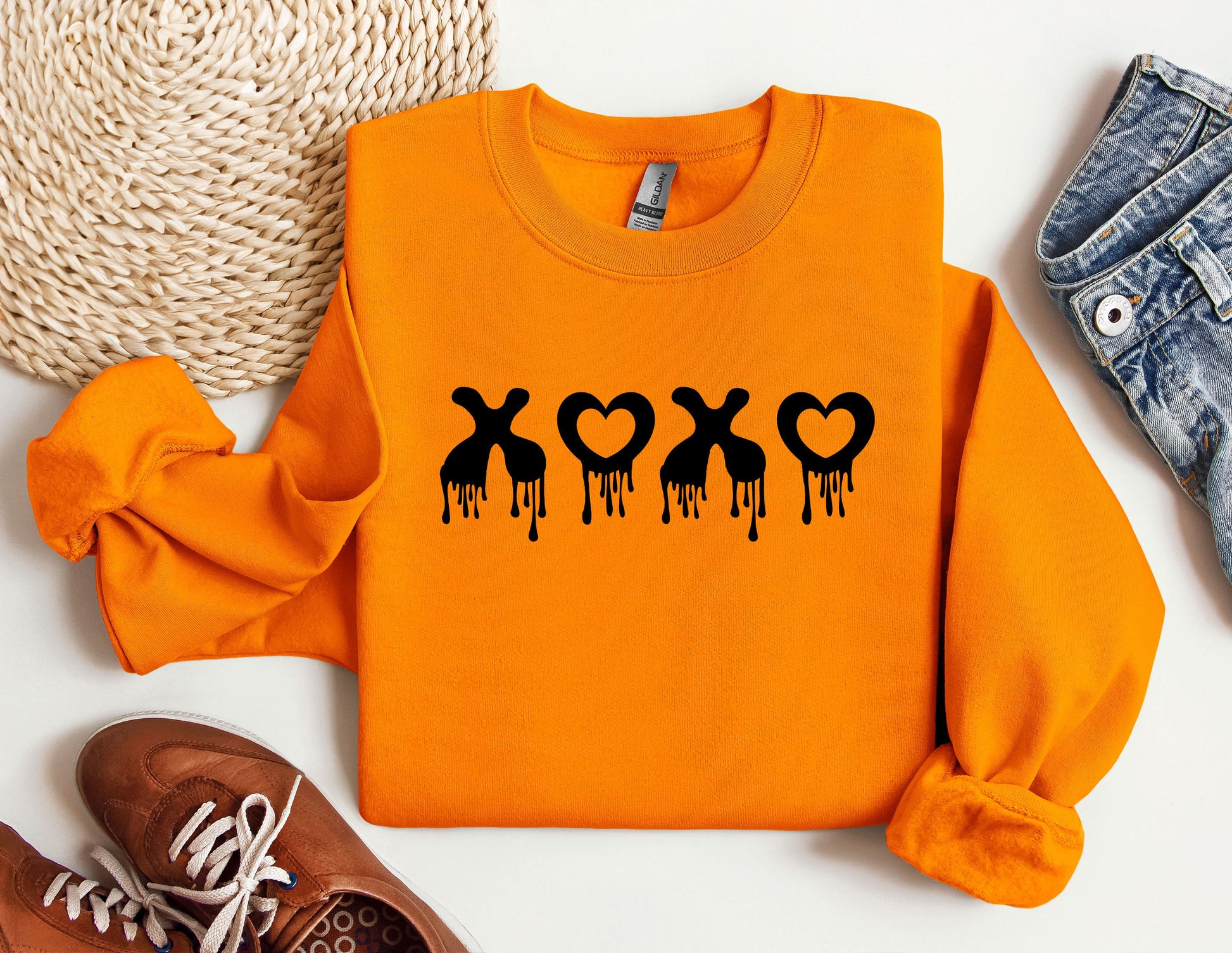 a pair of shoes and an orange shirt with the word xo on it