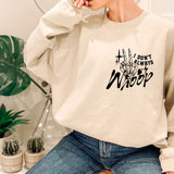 a woman sitting on a stool wearing a sweatshirt