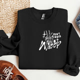 a black sweatshirt with white writing on it next to a pair of shoes
