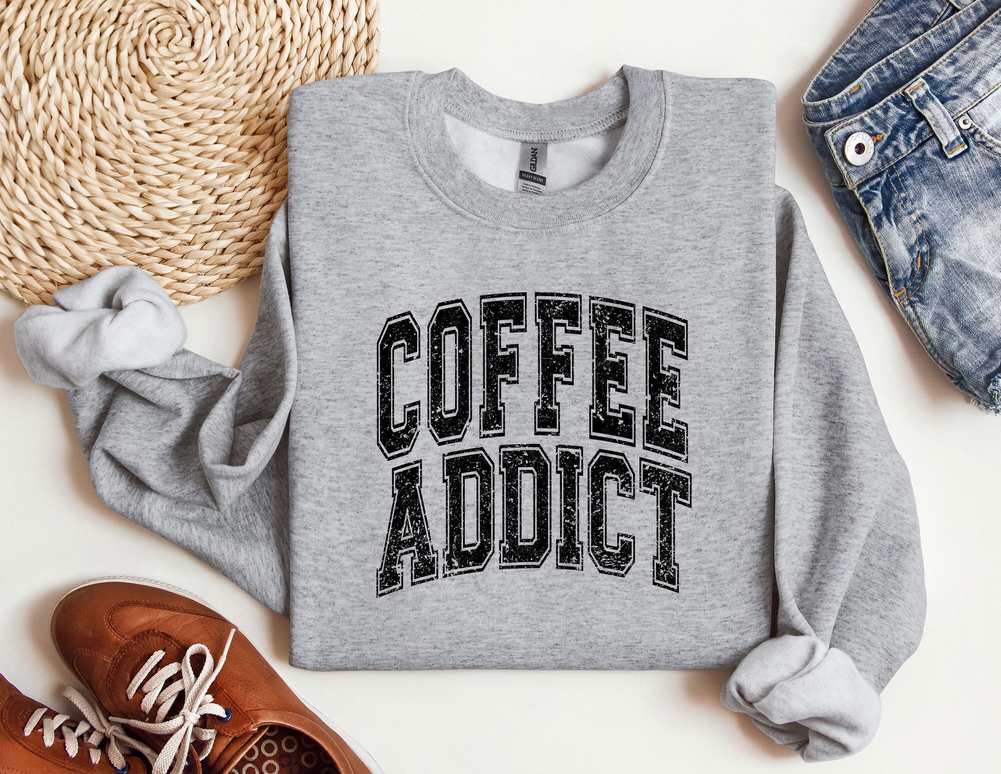 a sweatshirt that says coffee addict next to a pair of shoes