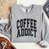 a sweatshirt that says coffee addict next to a pair of shoes