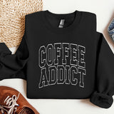a sweatshirt that says coffee addict next to a pair of sneakers