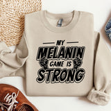 a sweatshirt that says, my melanin game is strong