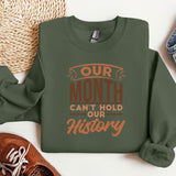 a green sweatshirt that says our month can't hold our history