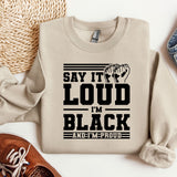 a sweater that says, say it's loud in black and a pair of