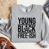 a young and black t - shirt sitting on top of a pair of jeans