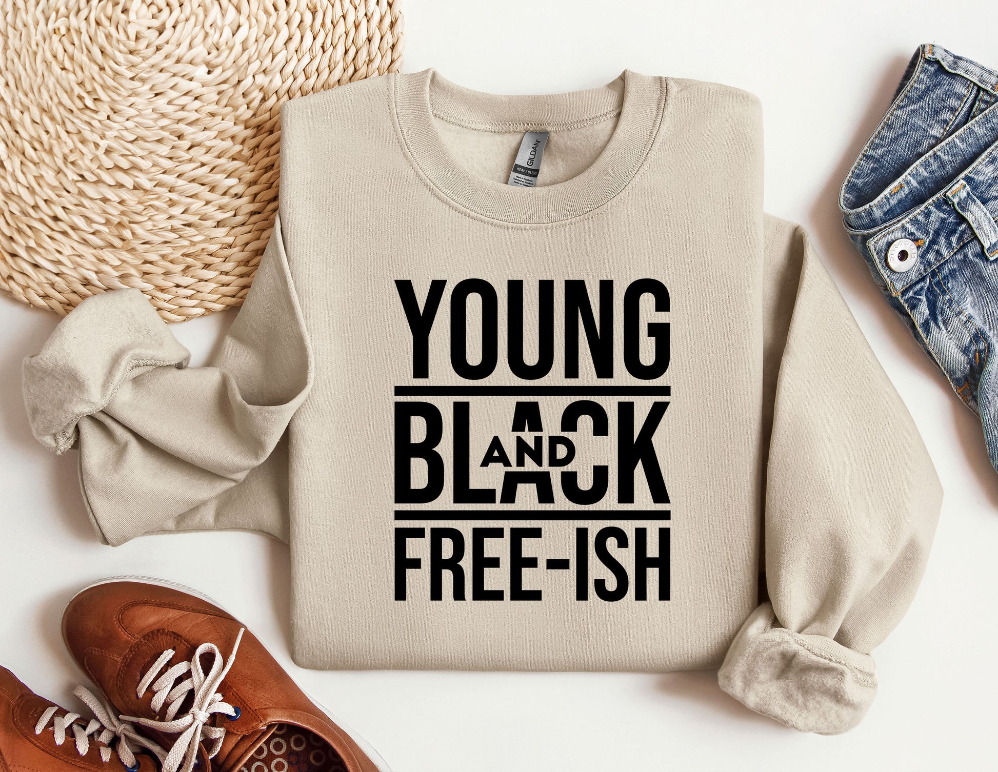 a sweater that says young and black free - ish next to a pair of