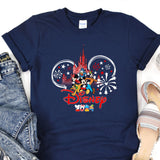 a mickey mouse shirt with fireworks and a castle in the background