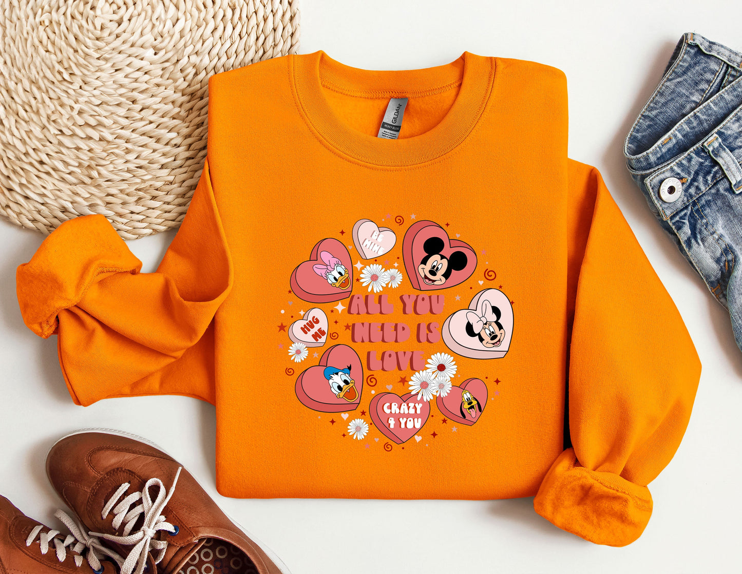 a pair of shoes and an orange sweatshirt with mickey mouse on it