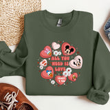 a green sweatshirt with hearts and mickey mouses on it