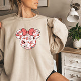 a woman wearing a sweatshirt with a minnie mouse face on it