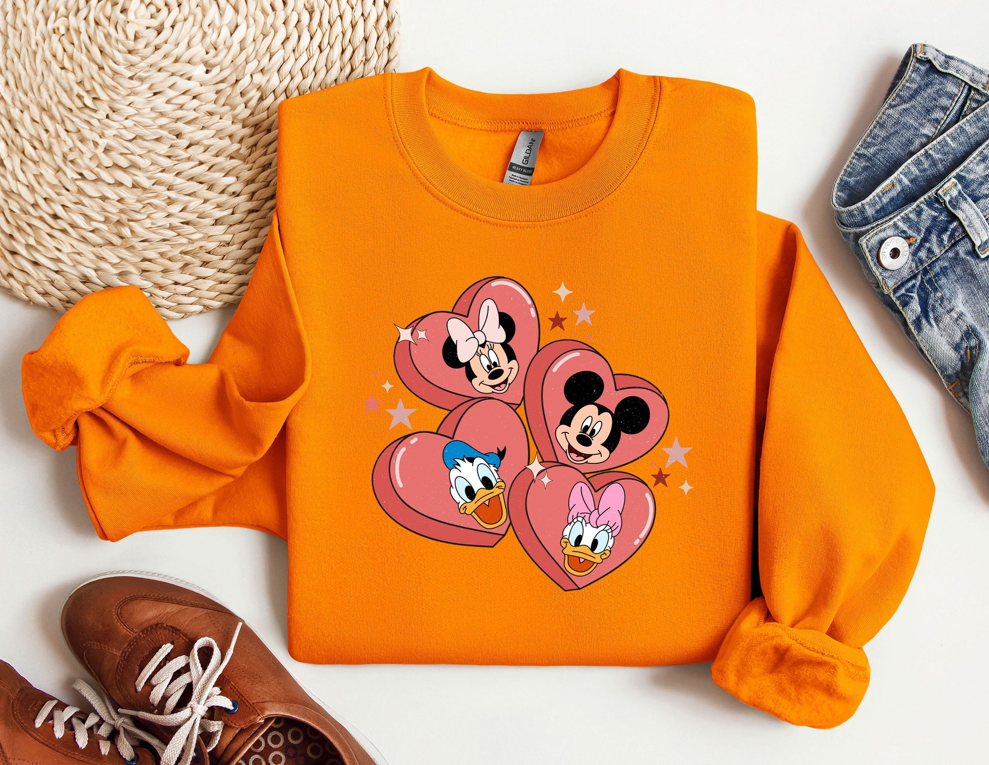 a pair of sneakers, a pair of jeans, and an orange mickey mouse shirt