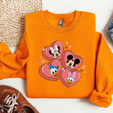 a pair of sneakers, a pair of jeans, and an orange mickey mouse shirt