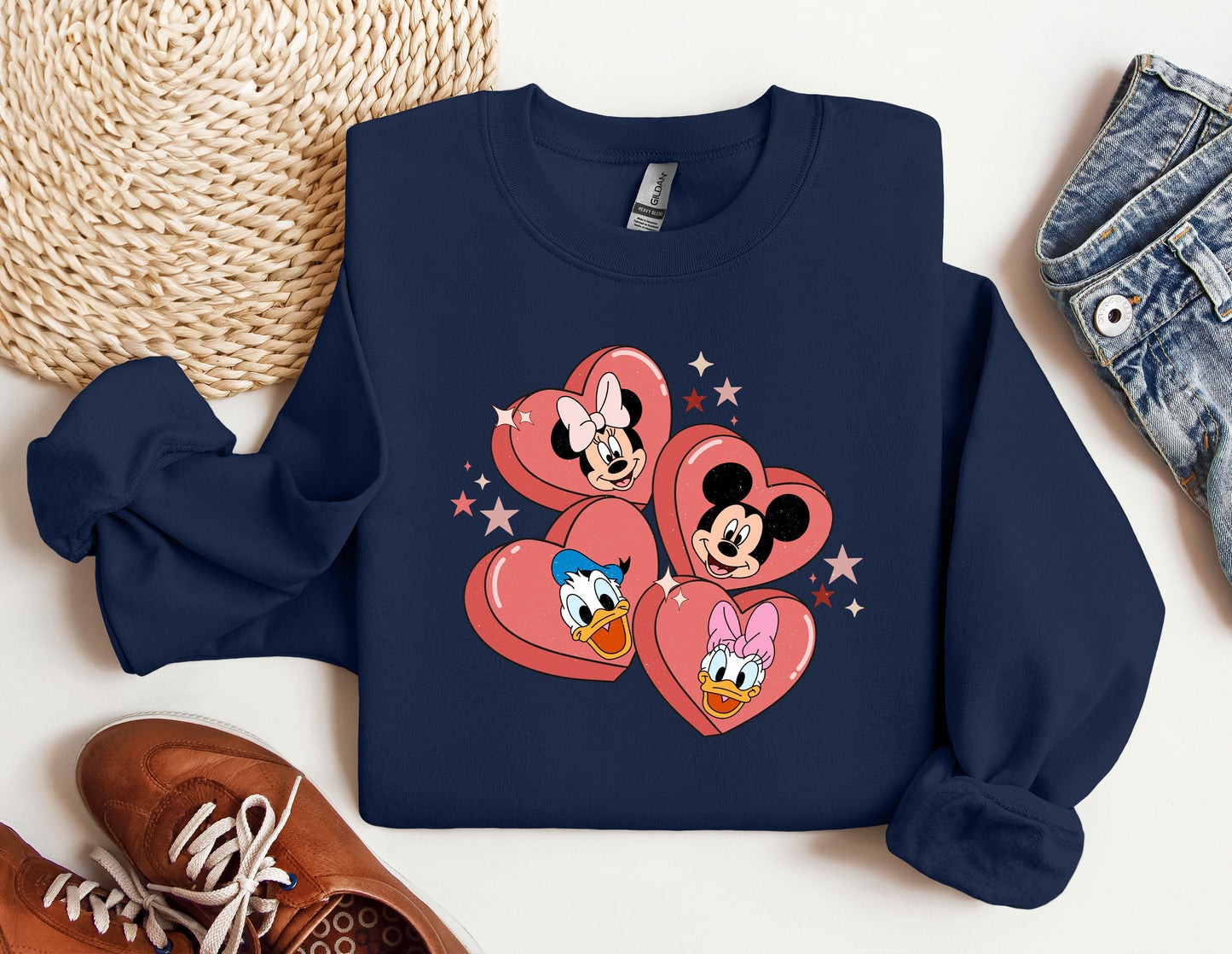 a mickey and minnie mouse heart sweatshirt next to a pair of sneakers