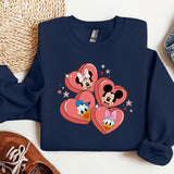 a mickey and minnie mouse heart sweatshirt next to a pair of sneakers