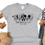 a mickey and mickey mouse t - shirt sitting on top of a pile of leaves