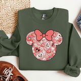 a green sweatshirt with a pink bow on it