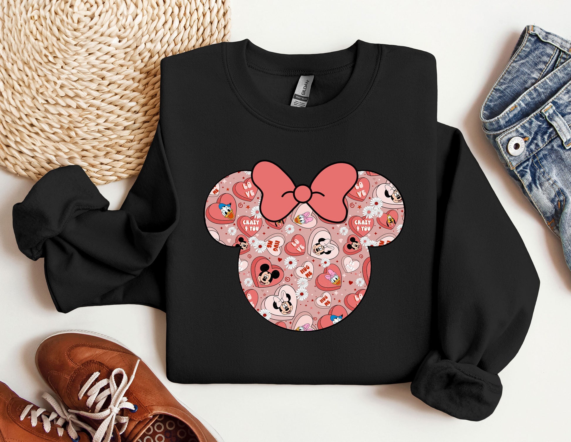 a mickey mouse sweatshirt with a pink bow on it