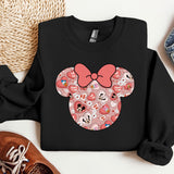 a mickey mouse sweatshirt with a pink bow on it