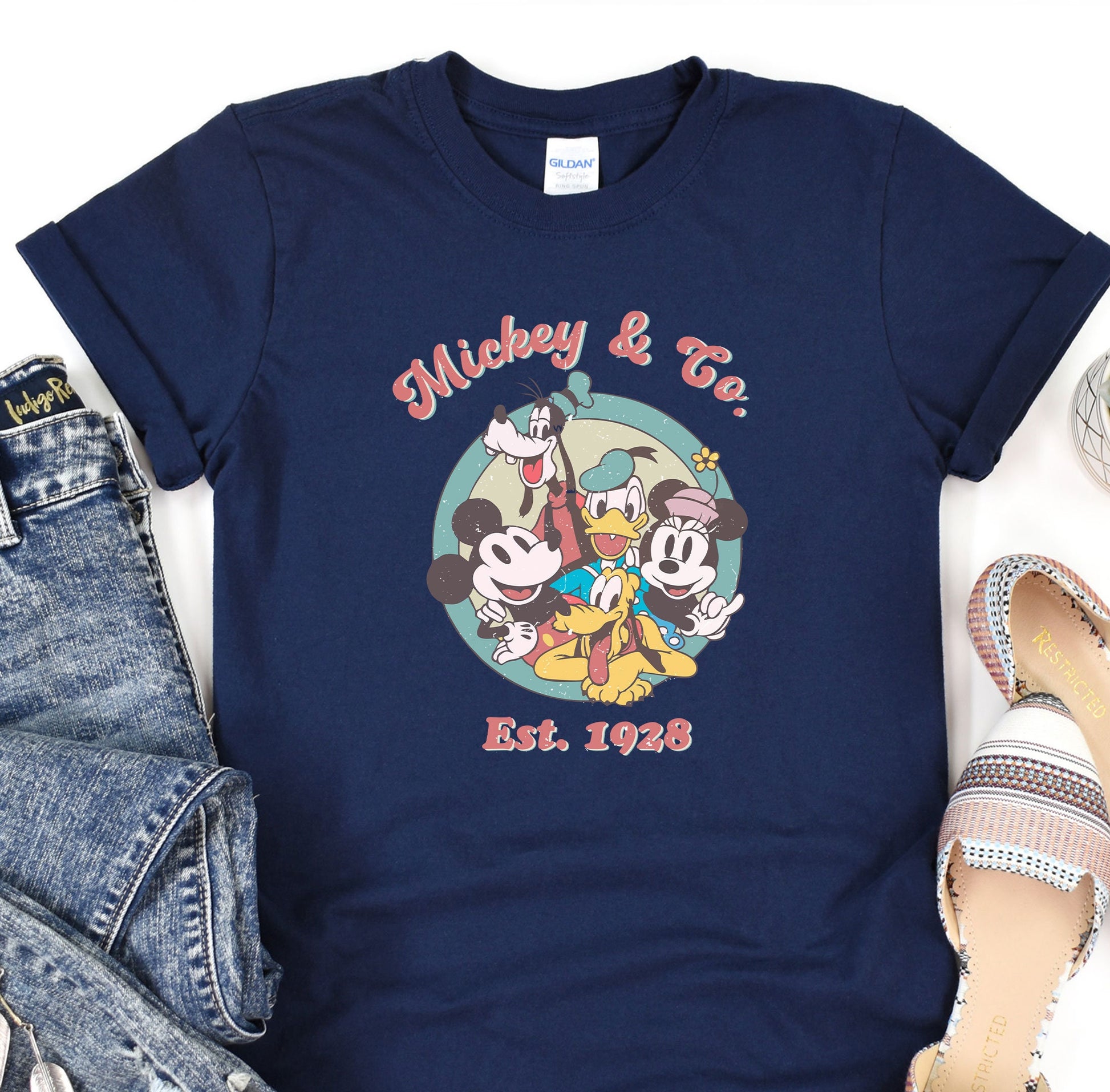 a mickey and mickey mouse t - shirt next to a pair of jeans