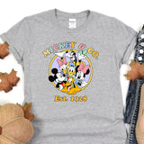 a mickey mouse t - shirt sitting on top of a pile of leaves