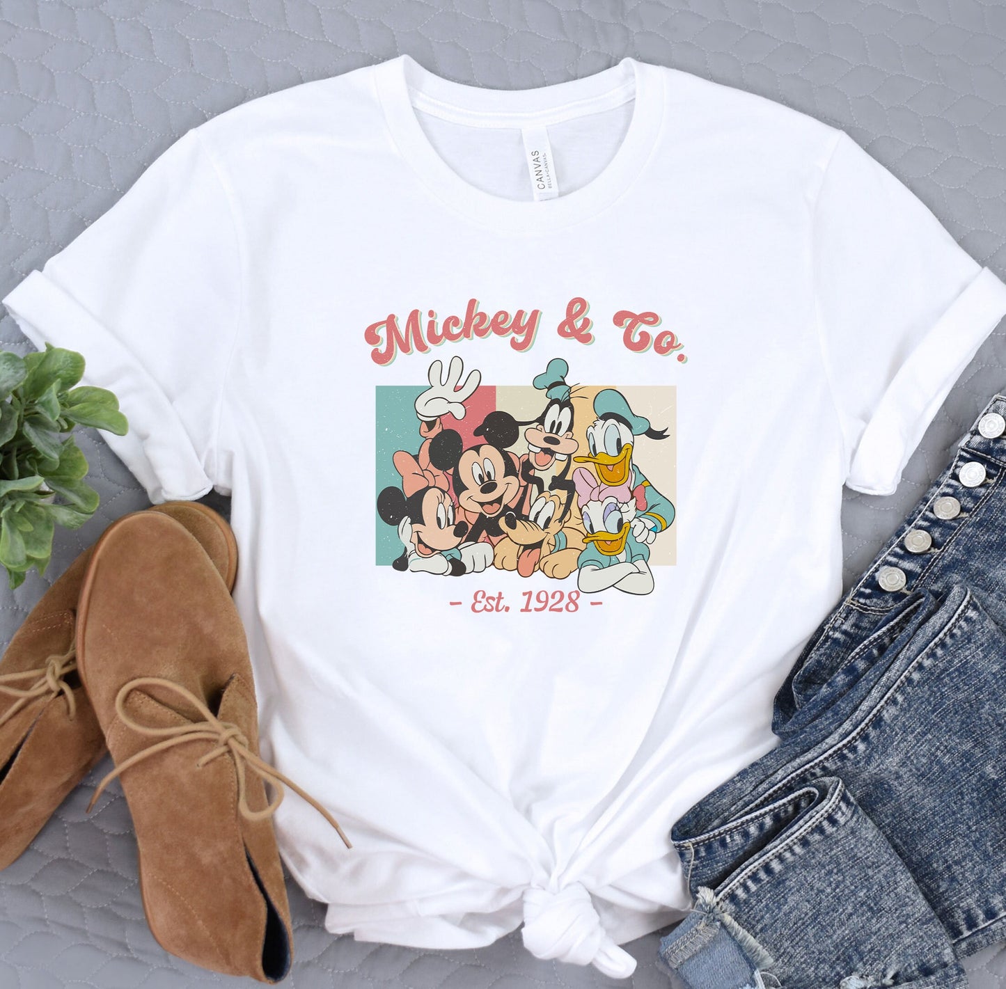 a mickey and mickey mouse t - shirt next to a pair of jeans