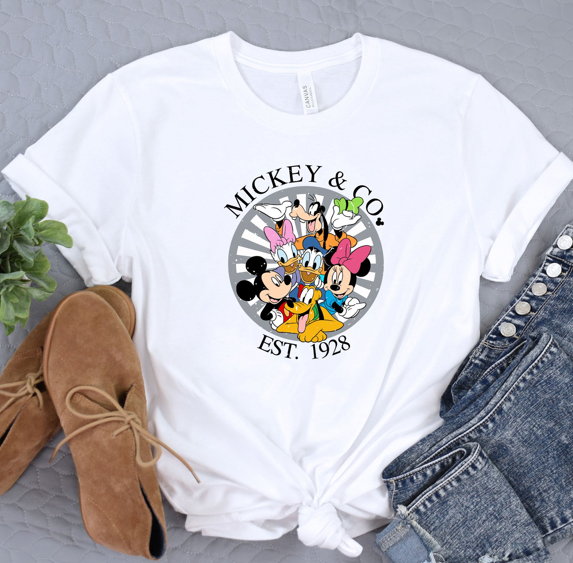 a mickey and mickey mouse t - shirt sitting on top of a table