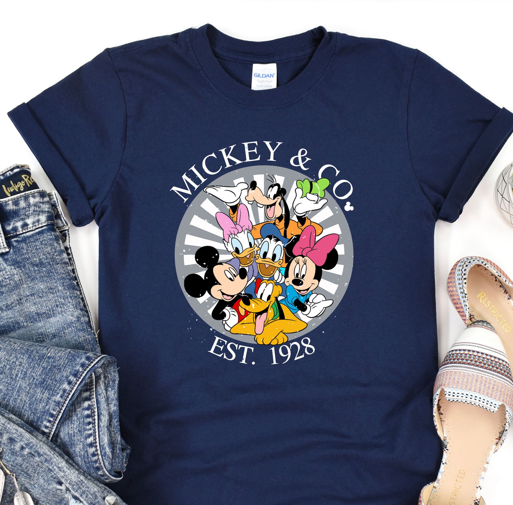 a mickey mouse and friends t - shirt on a pair of jeans