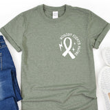 a green shirt with a white ribbon and a pair of jeans
