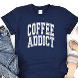 a t - shirt that says coffee addict next to a pair of jeans