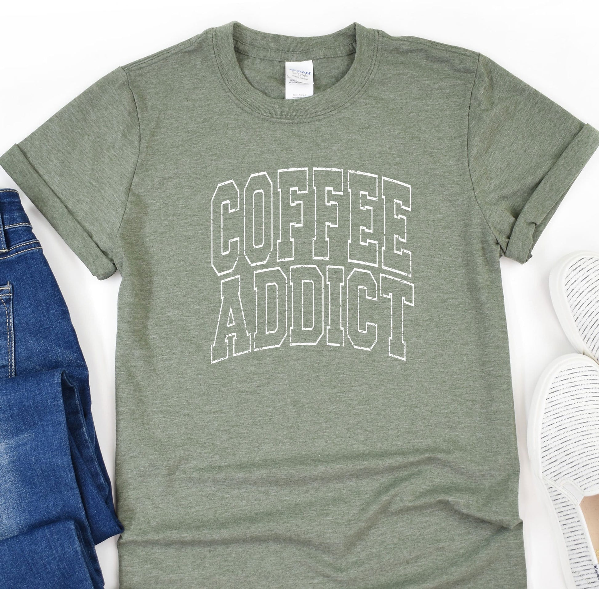 a t - shirt that says coffee adict next to a pair of jeans