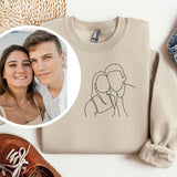 a sweater with a picture of a couple on it next to a pair of shoes