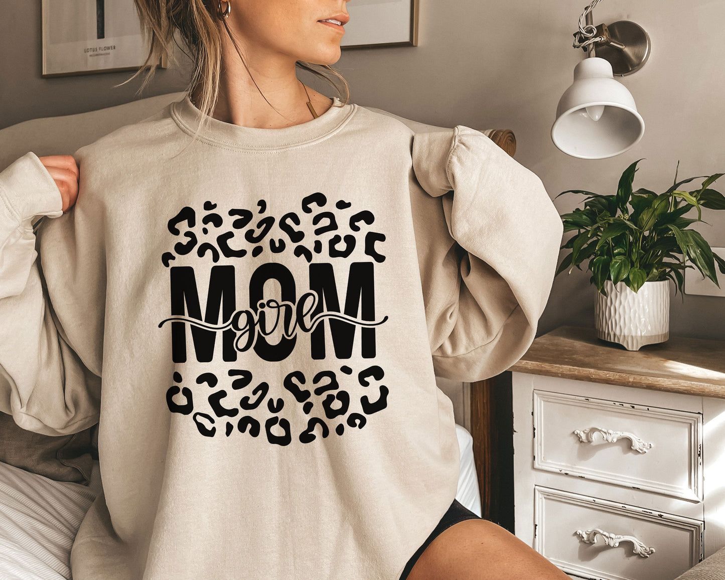 a woman wearing a sweatshirt with the word mom printed on it