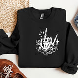 a black sweatshirt with a skull and flowers on it