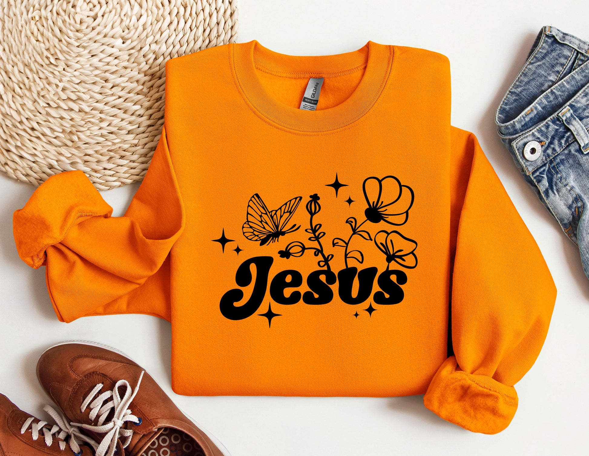 an orange sweatshirt with the word jesus printed on it