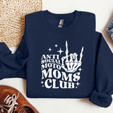 a sweatshirt that says anti social moms club next to a pair of sneakers