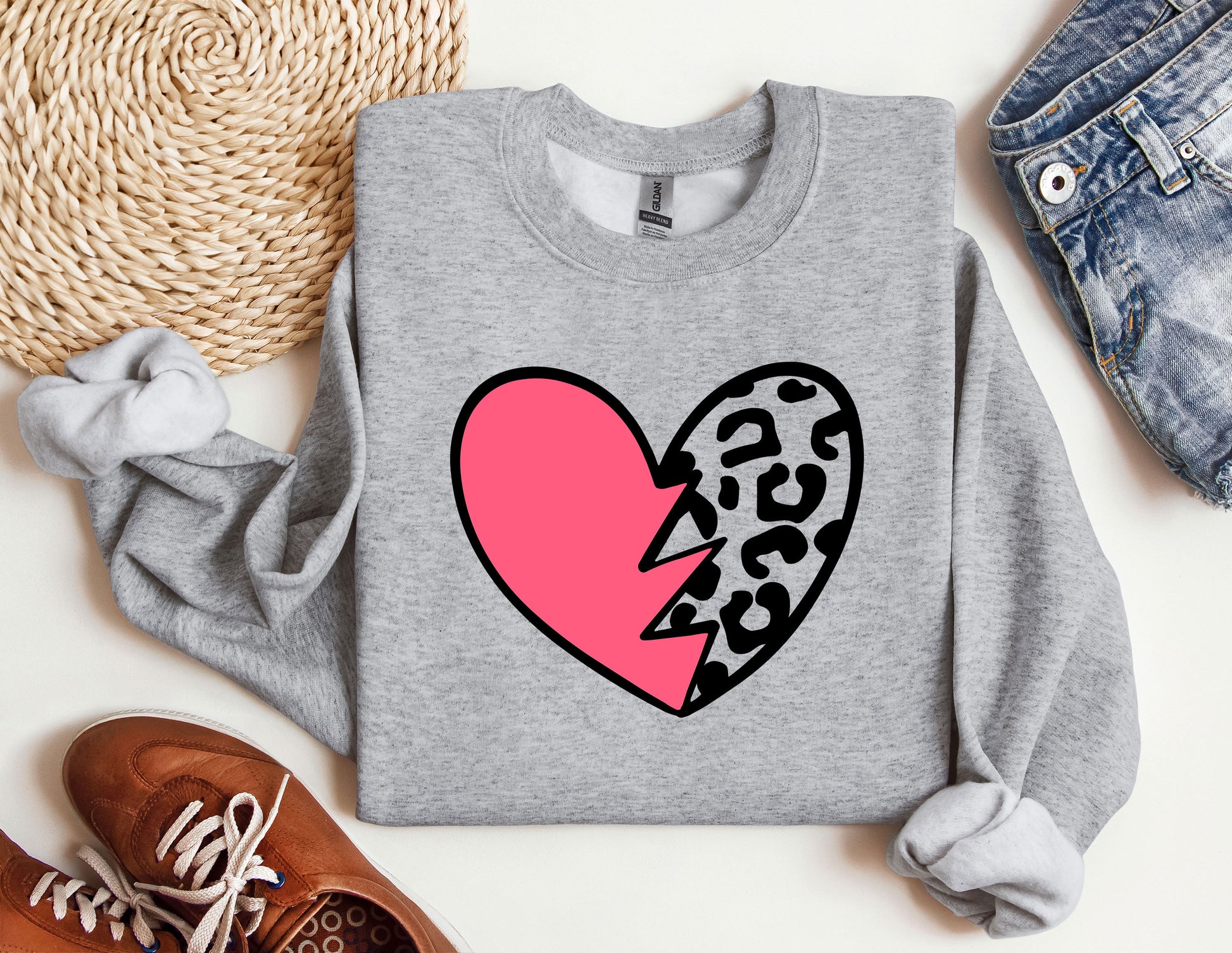 a grey sweater with a pink heart and a leopard print