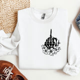 a white sweatshirt with a black graphic of a church and flowers