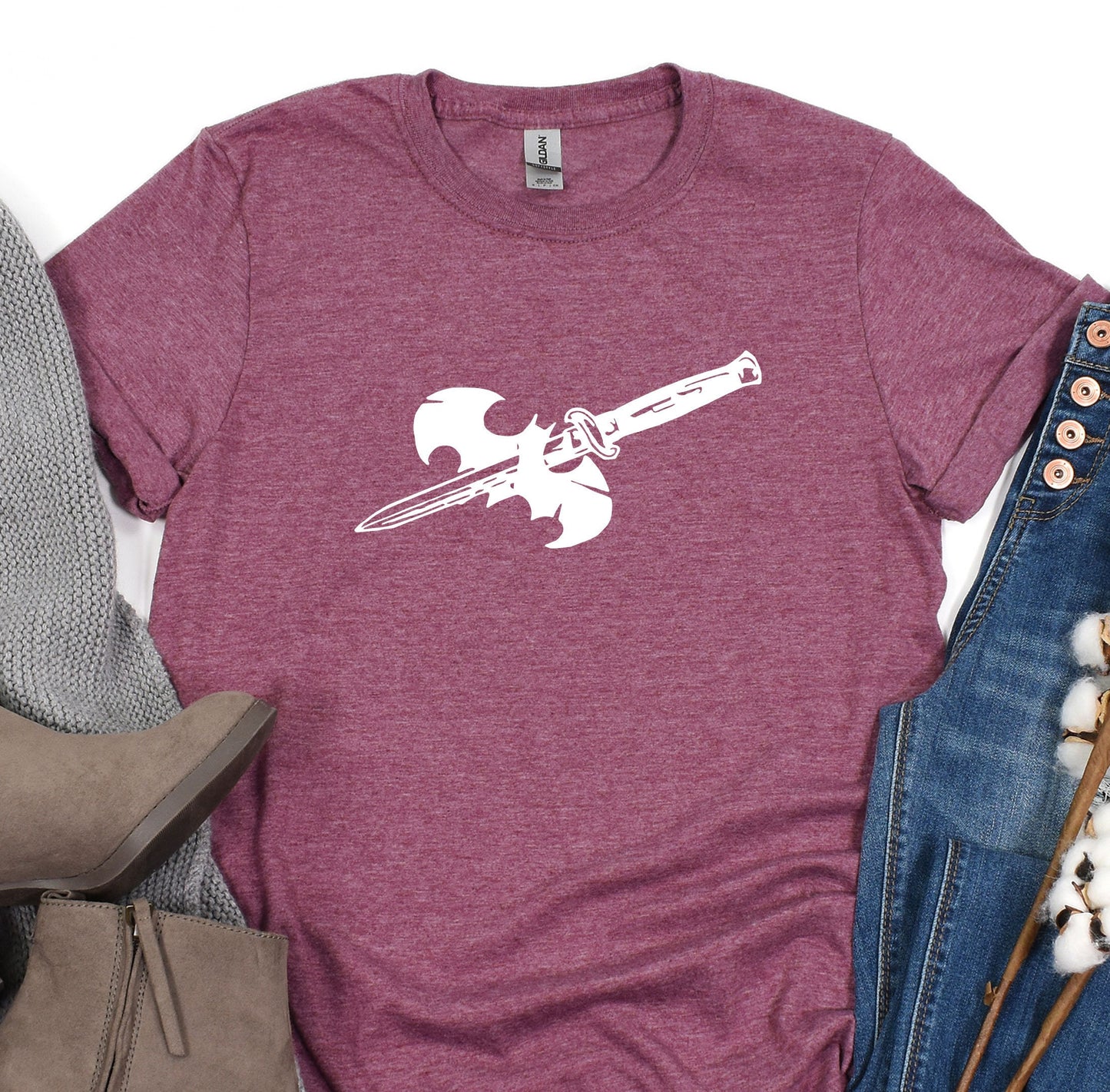 a t - shirt with a gun on it next to a pair of jeans