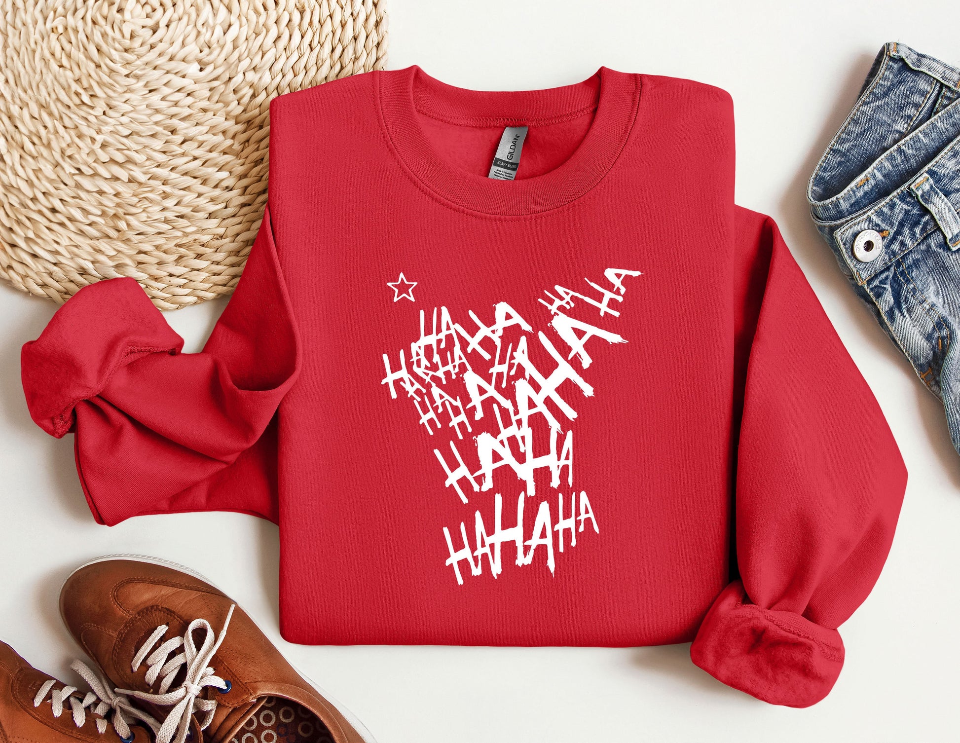 a red sweatshirt with white letters on it next to a pair of shoes