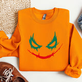 a pair of shoes and an orange sweater with a face drawn on it