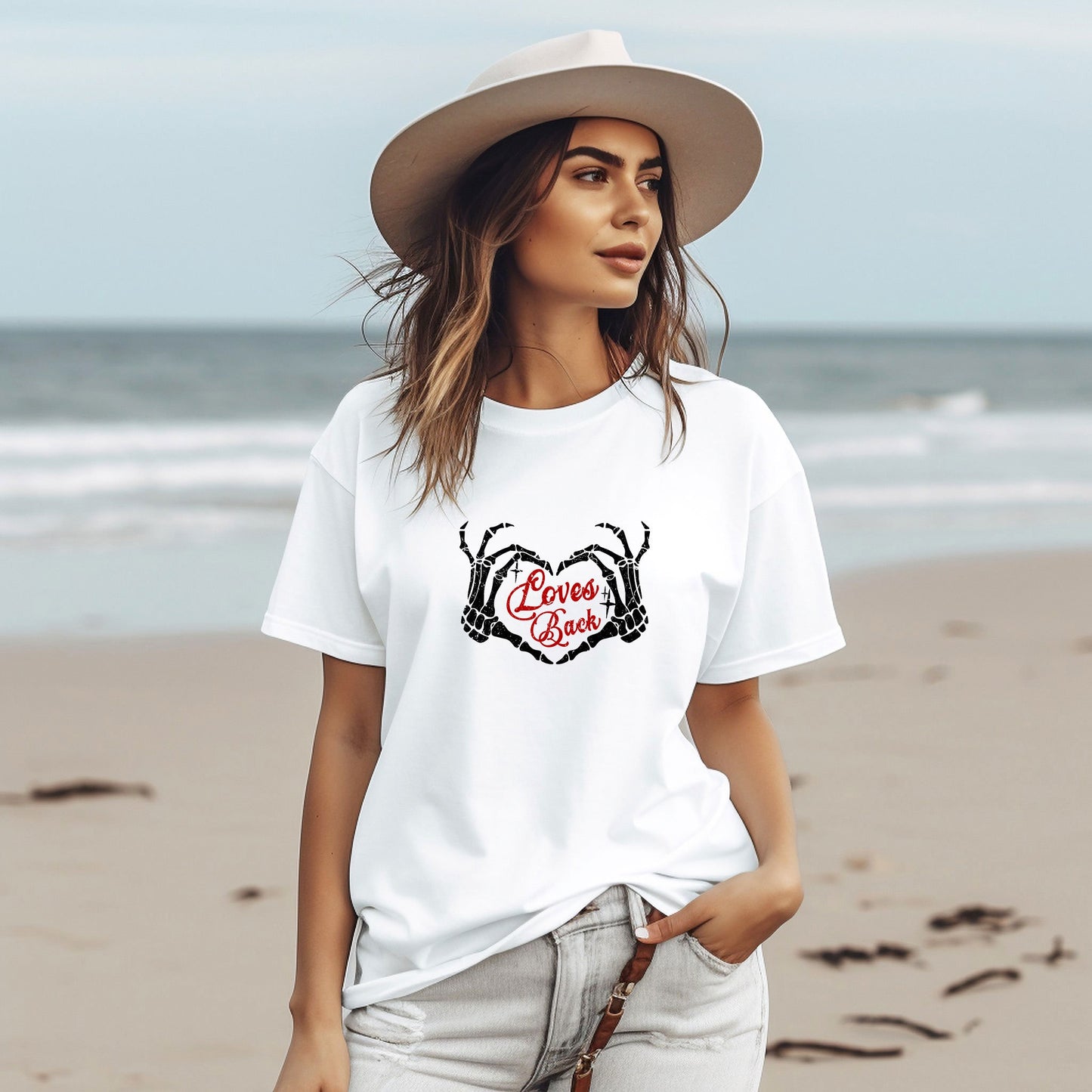 a woman standing on a beach wearing a hat