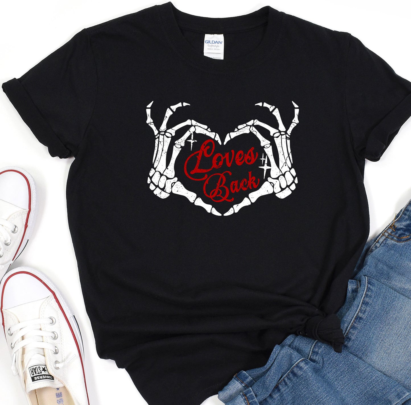 a black t - shirt with two hands holding a heart