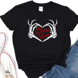 a black t - shirt with two hands holding a heart